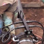 Magnetischer Rollenblock im Außeneinsatz auf einer Pipeline-Baustelle zur präzisen Führung und Unterstützung eines Rohrsegments während der Bearbeitung.