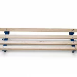 Mobile Holzkufe mit blauem Stahlunterbau und Rollen zum einfachen Transport von Rohrelementen und schweren Lasten als Freisteller.hrend der Dämmerung.