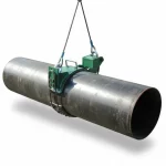 Eine freigestellte mechanische Rohrhebezange auf weißem Hintergrund, die ein großes dunkles Stahlrohr anhebt. Die Zange besteht aus einer grünen Metallkonstruktion mit Haltegriffen, die das Rohr fest umschließt. Das gesamte Hebewerkzeug ist über zwei Drahtseile mit Ösen und Schäkeln an einer (nicht sichtbaren) Krankonstruktion befestigt.