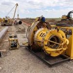 Hydraulische Innenzentrierklemme im Einsatz auf einer Pipeline-Baustelle zur Vorbereitung von Schweißarbeiten an großkalibrigen Rohrelementen.