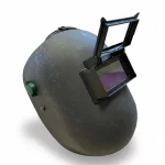 Ein freigestellter, dunkelgrauer Schweißerhelm mit rauer Oberflächenstruktur auf weißem Hintergrund. Der Helm verfügt über ein hochklappbares Sichtfenster (Flip-up-Visier) mit dunklem Schutzglas für Schweißarbeiten. An der Seite ist ein grüner Drehknopf zur Einstellung der Kopfhalterung sichtbar.